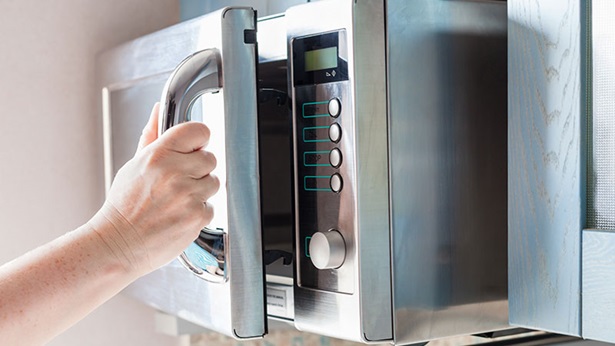 La porte d'un four à micro-ondes est ouverte.